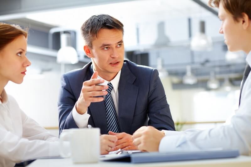 שיחה במשרד בין שלושה עמיתים לעבודה